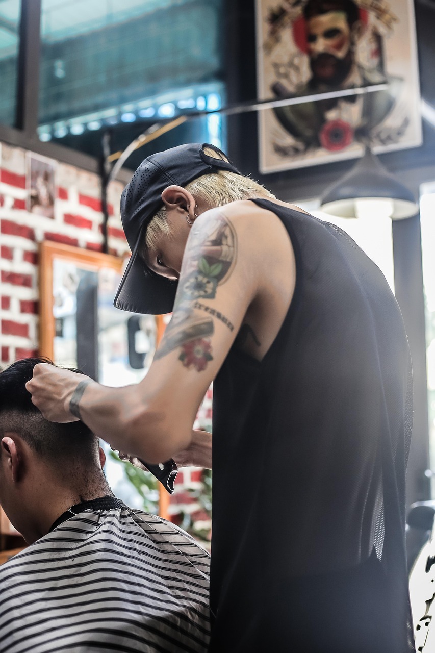 Muž strihá vlasy inému mužovi v barbershope.