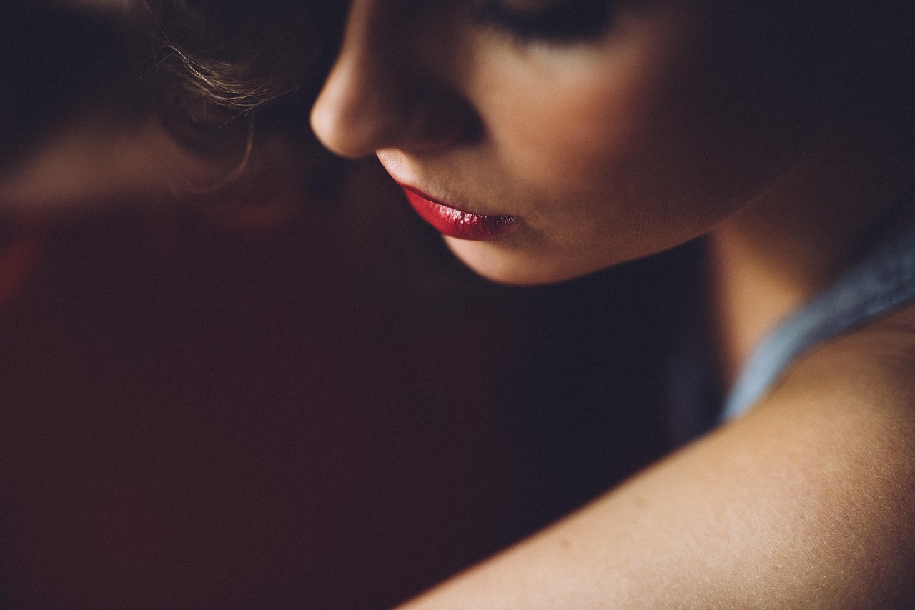 Detailný záber na ženu s červeným rúžom.