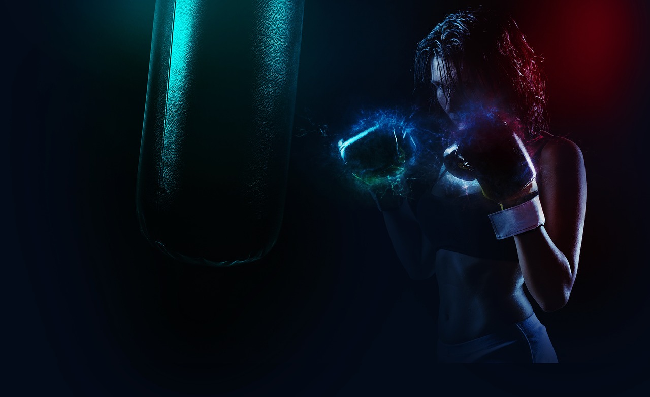 Žena v športových boxerkách trénuje s boxovacím vrecom.